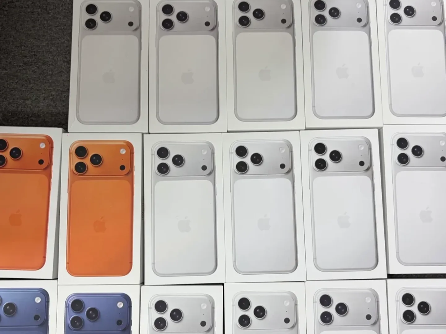 Recent boxed iPhone 17 Pro Max inventory in silver, orange, and blue for wholesale batch review